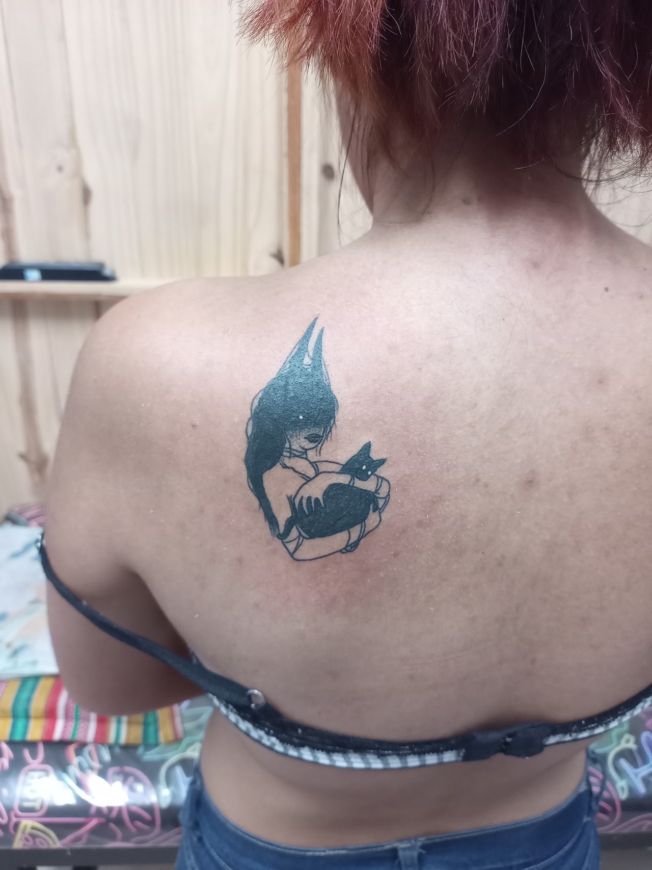 Tatuaje de chica con gato negro en la espalda